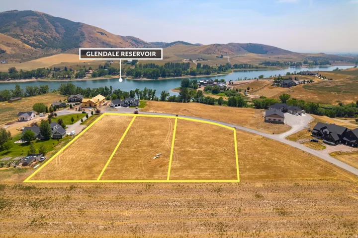 Expansive undeveloped lots with defined boundaries, situated with a body of water and distant hills in the background