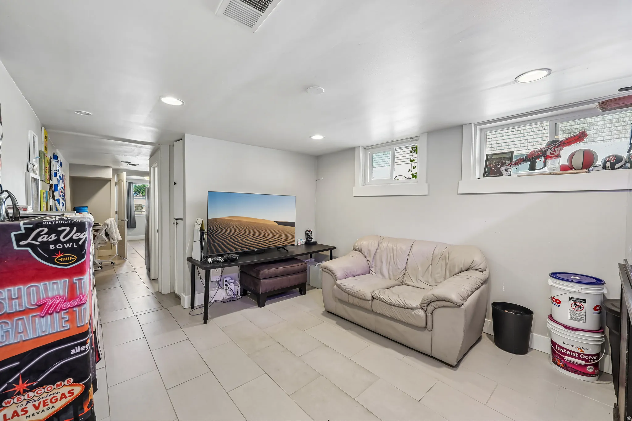 Recessed lighting and two windows illuminate this interior space featuring light-toned flooring