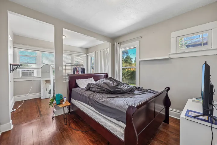 Wood-finish flooring throughout, multiple windows providing natural light, and a dedicated alcove space