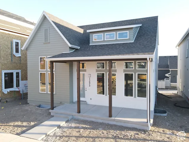 Exterior of Actual Home Progress-Modern two-story residence featuring a covered front porch, multiple large windows, and a prominent dormer