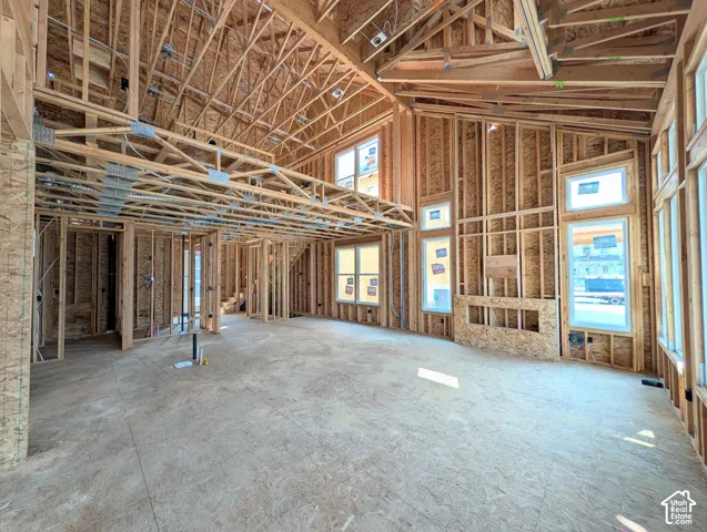 Actual Home Progress-Vaulted ceilings, exposed structural framing, multiple windows, and an integrated fireplace frame