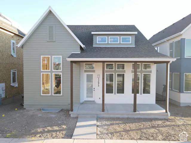 Exterior of Actual Home Progress-Contemporary exterior featuring a covered porch with dark-stained posts, a combination of horizontal siding and stucco, and multiple large windows