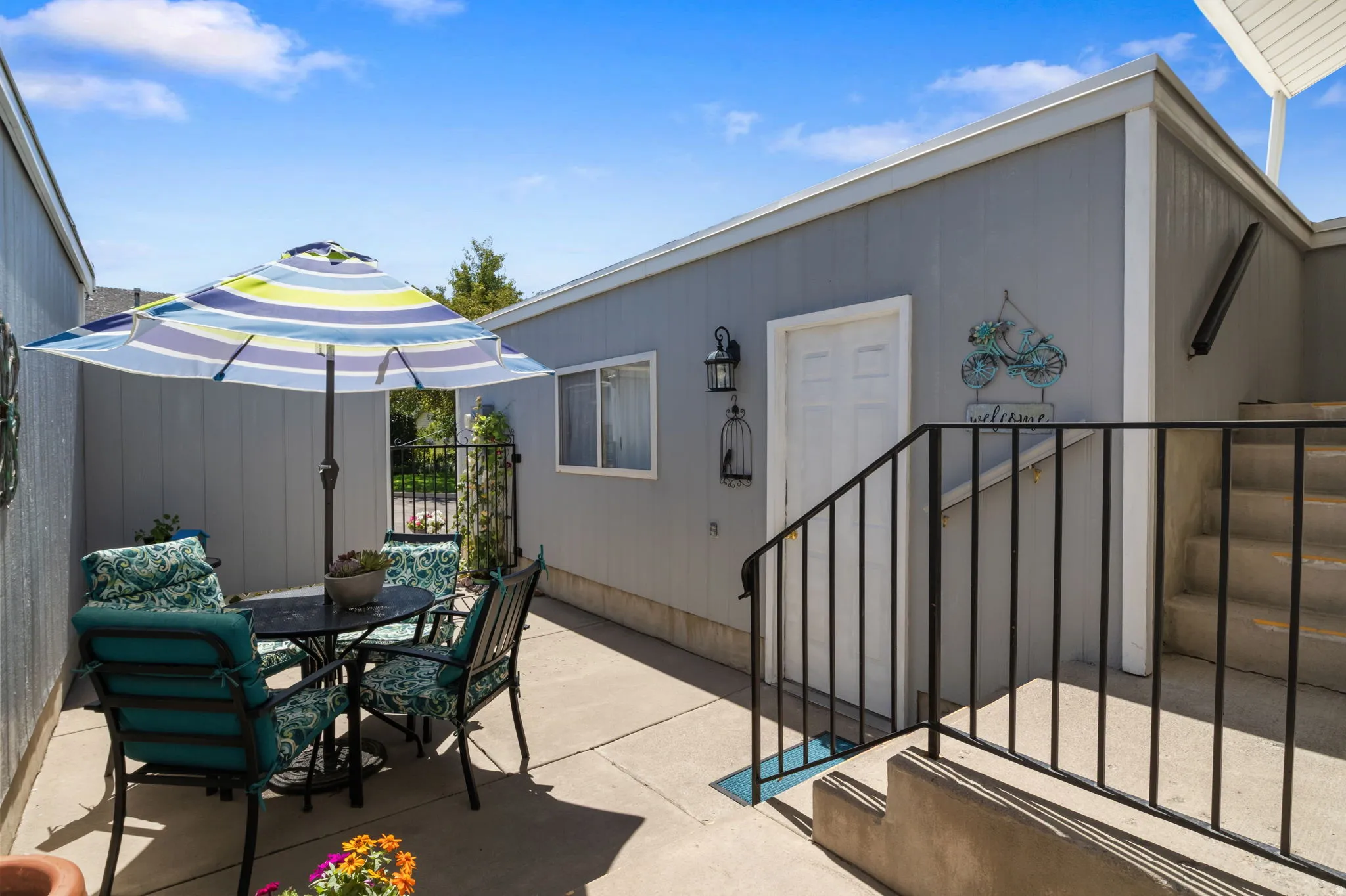 Private patio area with concrete flooring, exterior window, and concrete stairs with a metal railing