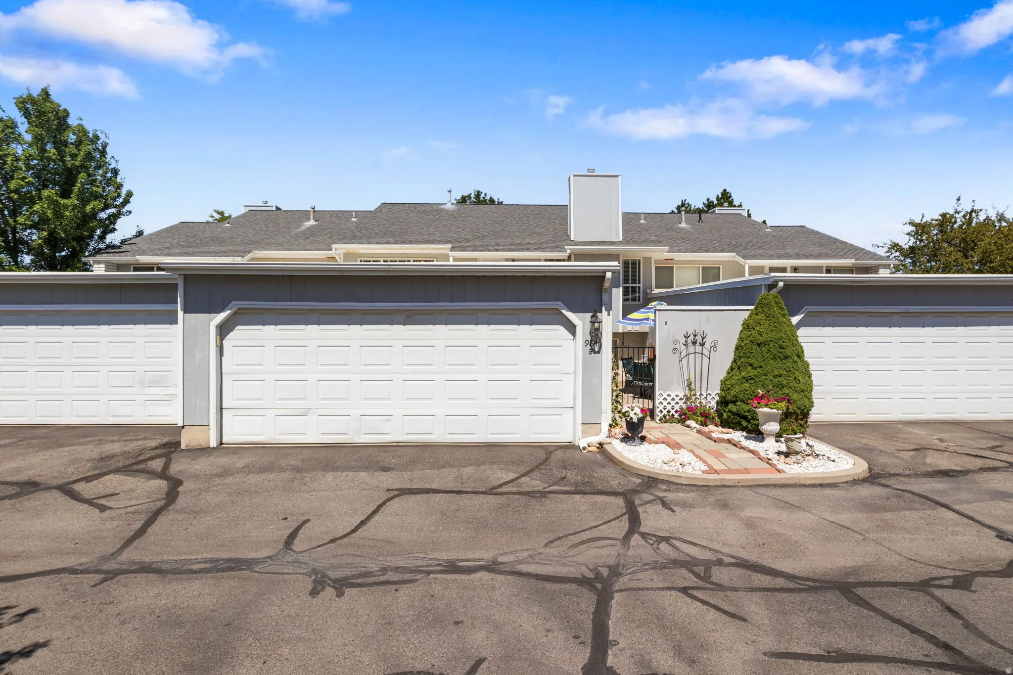 Attached two-car garage featuring panel doors and a paved driveway