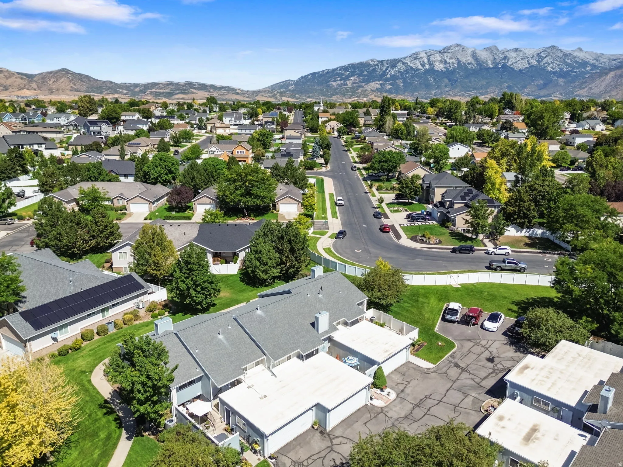 Residential neighborhood with mature trees and mountain scenery