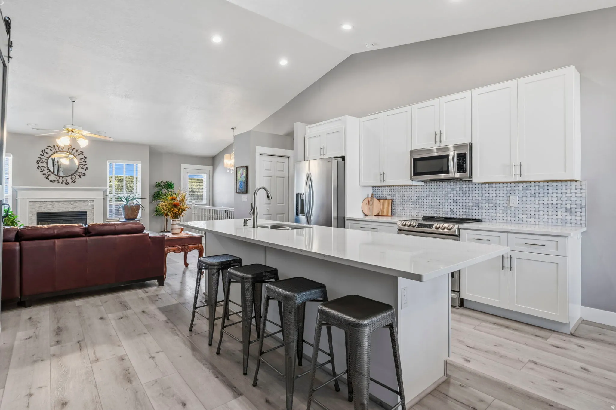 Kitchen island with a light-toned countertop, white cabinetry, and stainless steel appliances