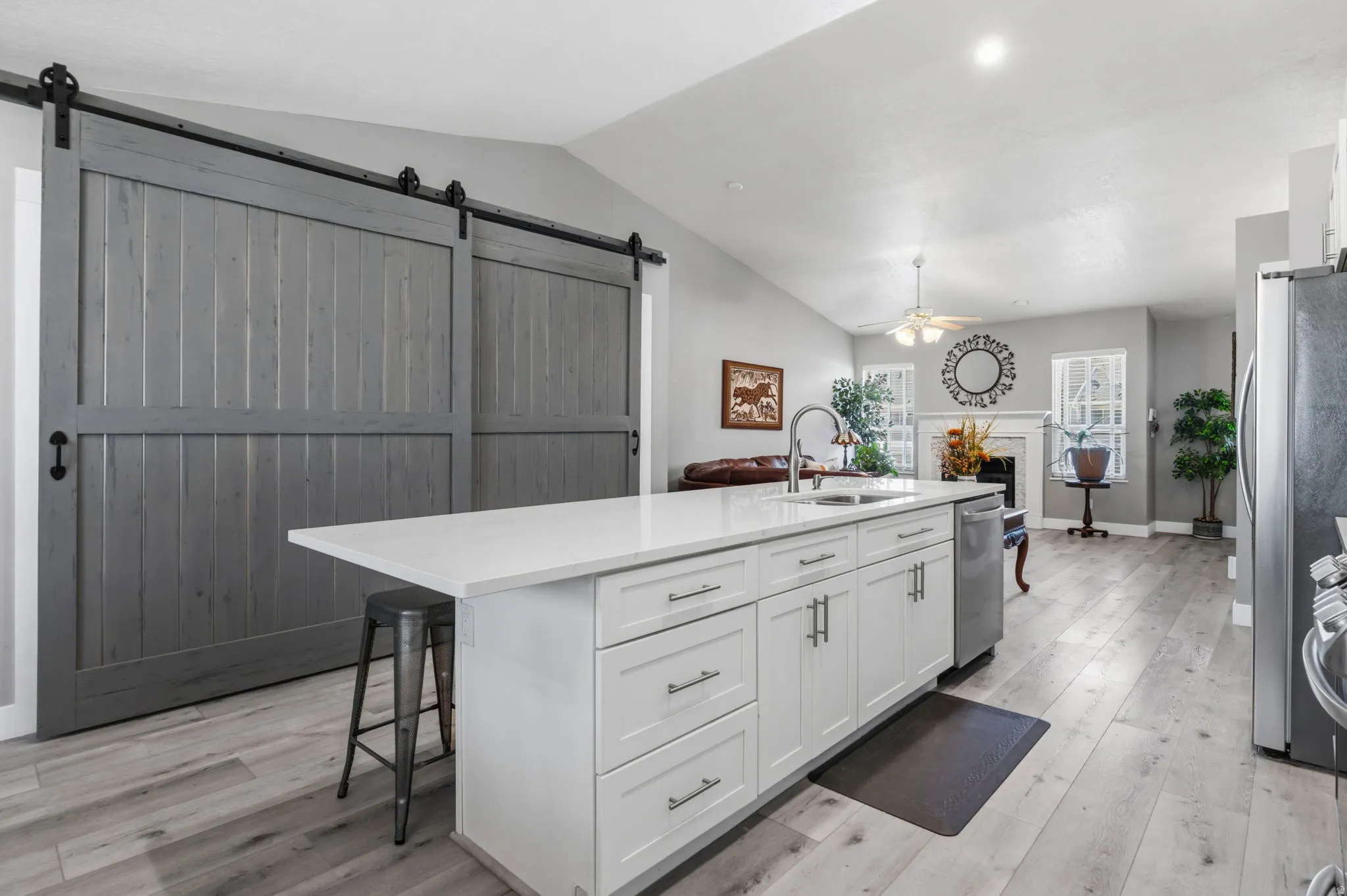 Kitchen island with white cabinetry, integrated sink, and light-toned countertop