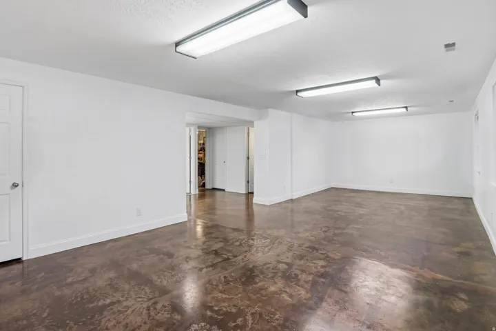 Spacious interior featuring a durable concrete floor, white walls, and bright overhead lighting