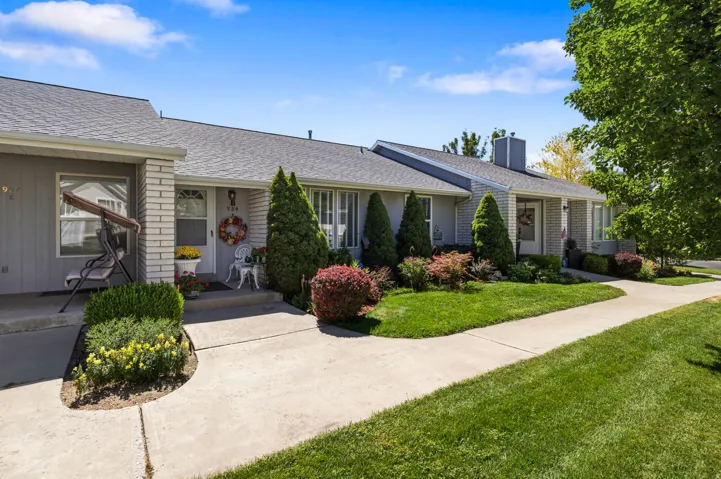 Exterior featuring gray siding, light brick accents, and a gray shingle roof