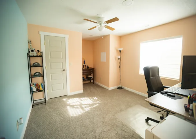 Wall-to-wall carpeting and a ceiling fan with integrated lighting