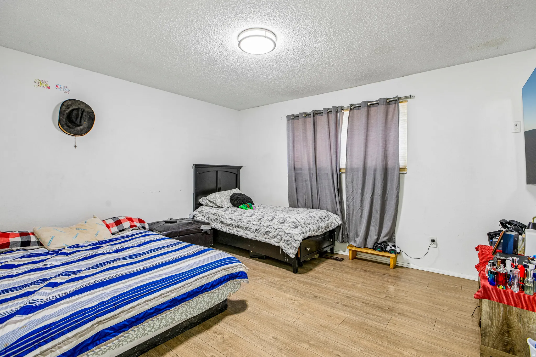Recessed ceiling light, wood-finish flooring, and window with curtains