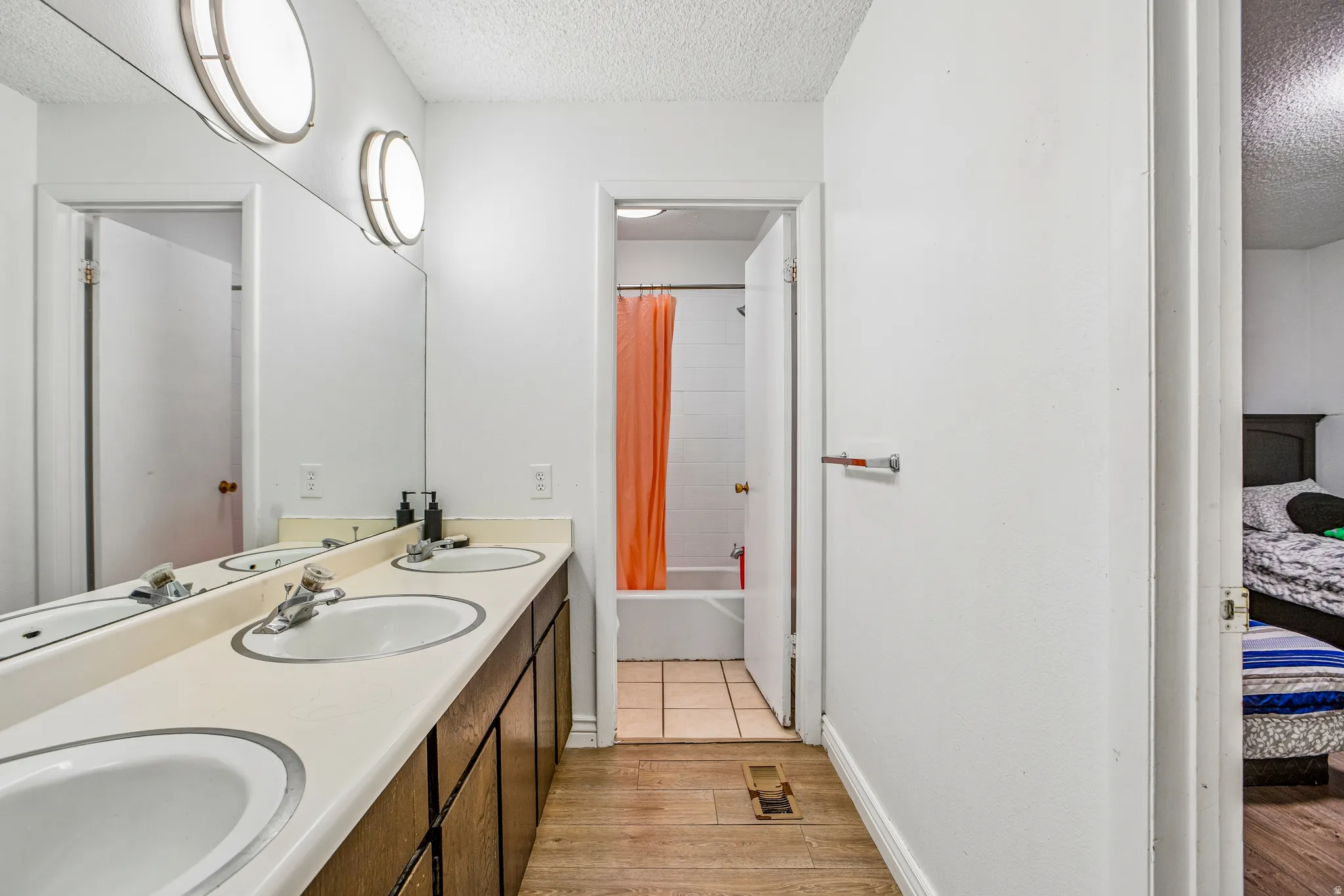 Dual vanity with integrated sinks, full-width mirror, and overhead lighting