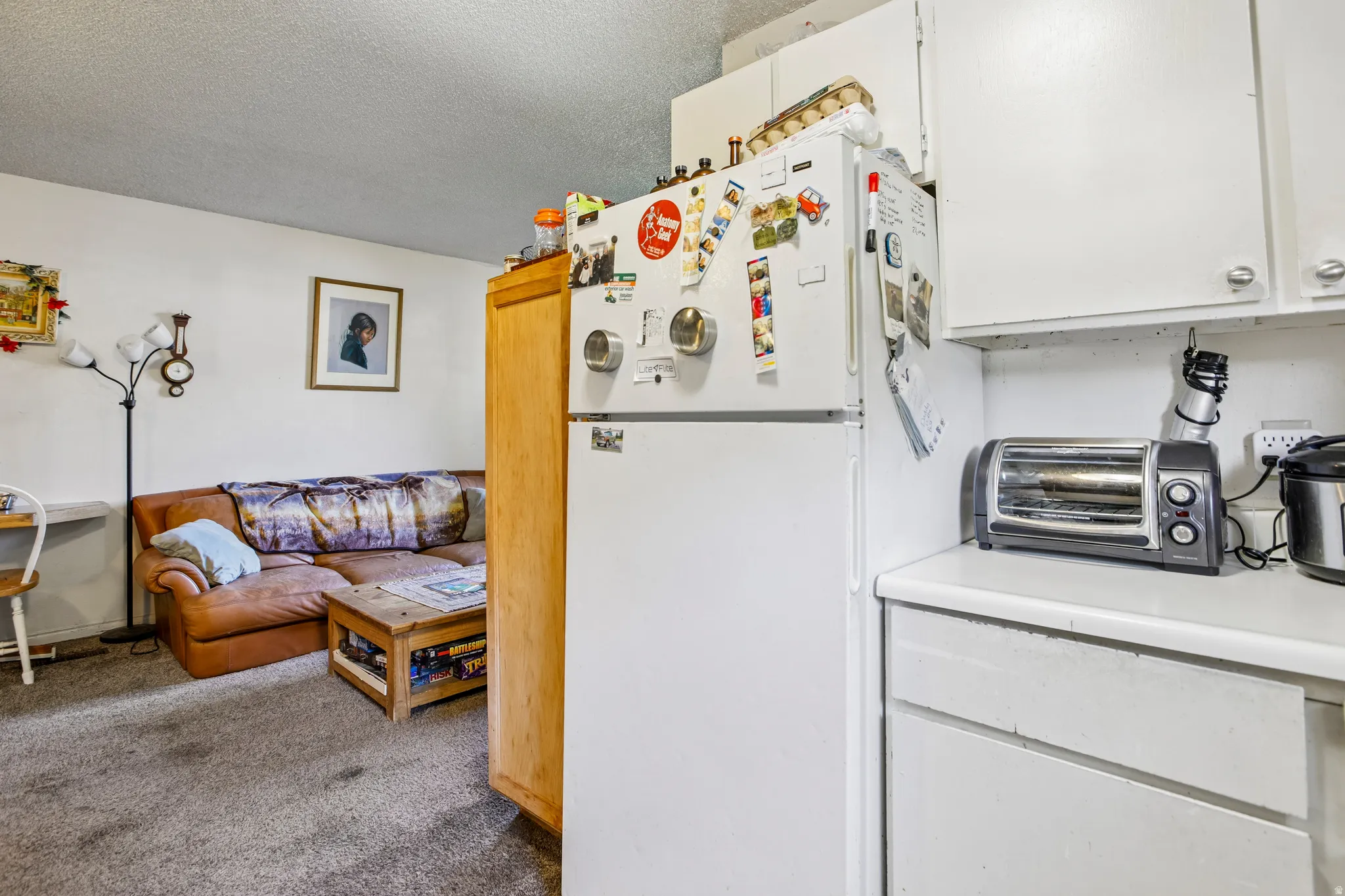 Galley-style kitchen with white cabinetry and white countertops