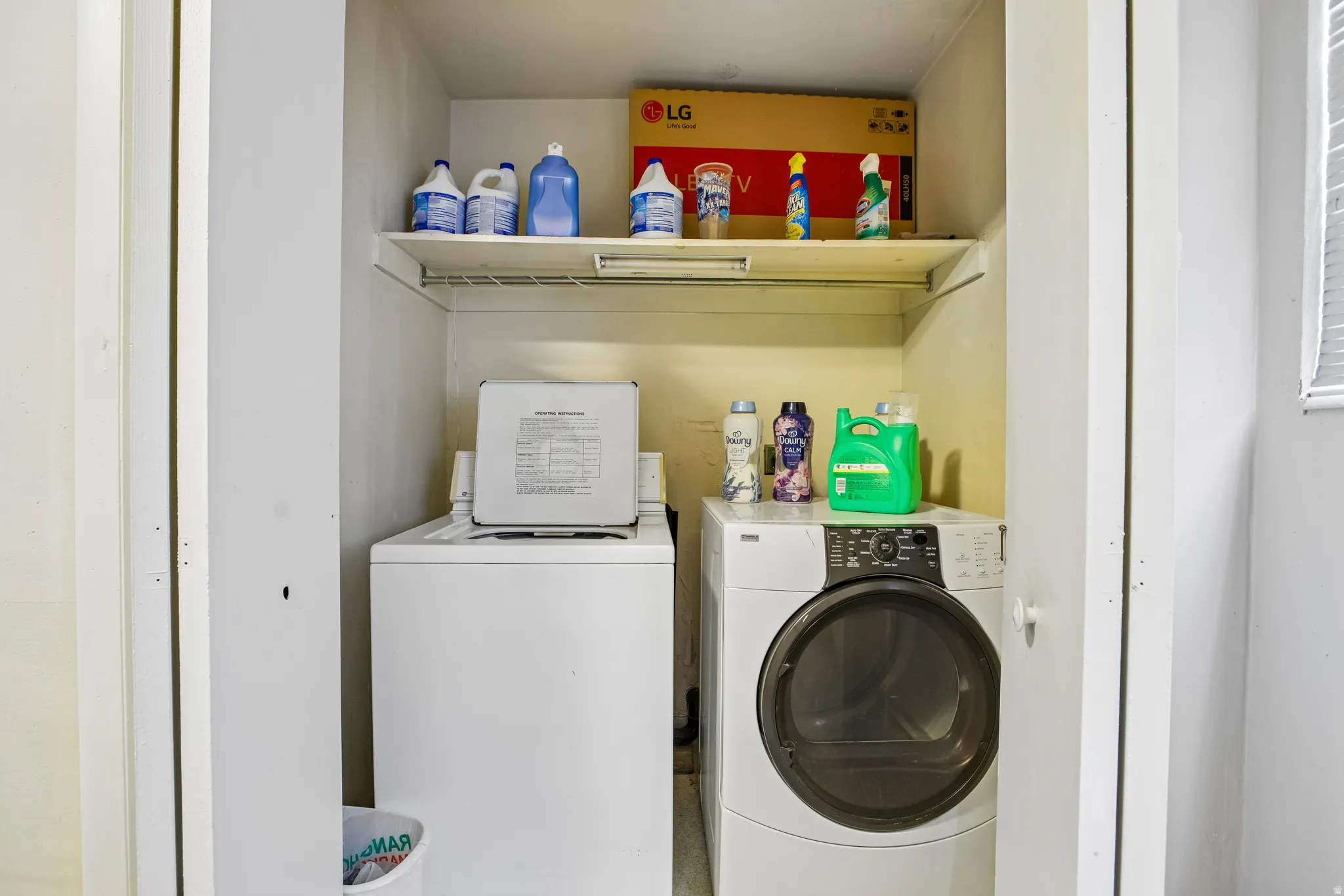 Closet laundry area featuring a top-load washing machine, front-load dryer, and a wire storage shelf