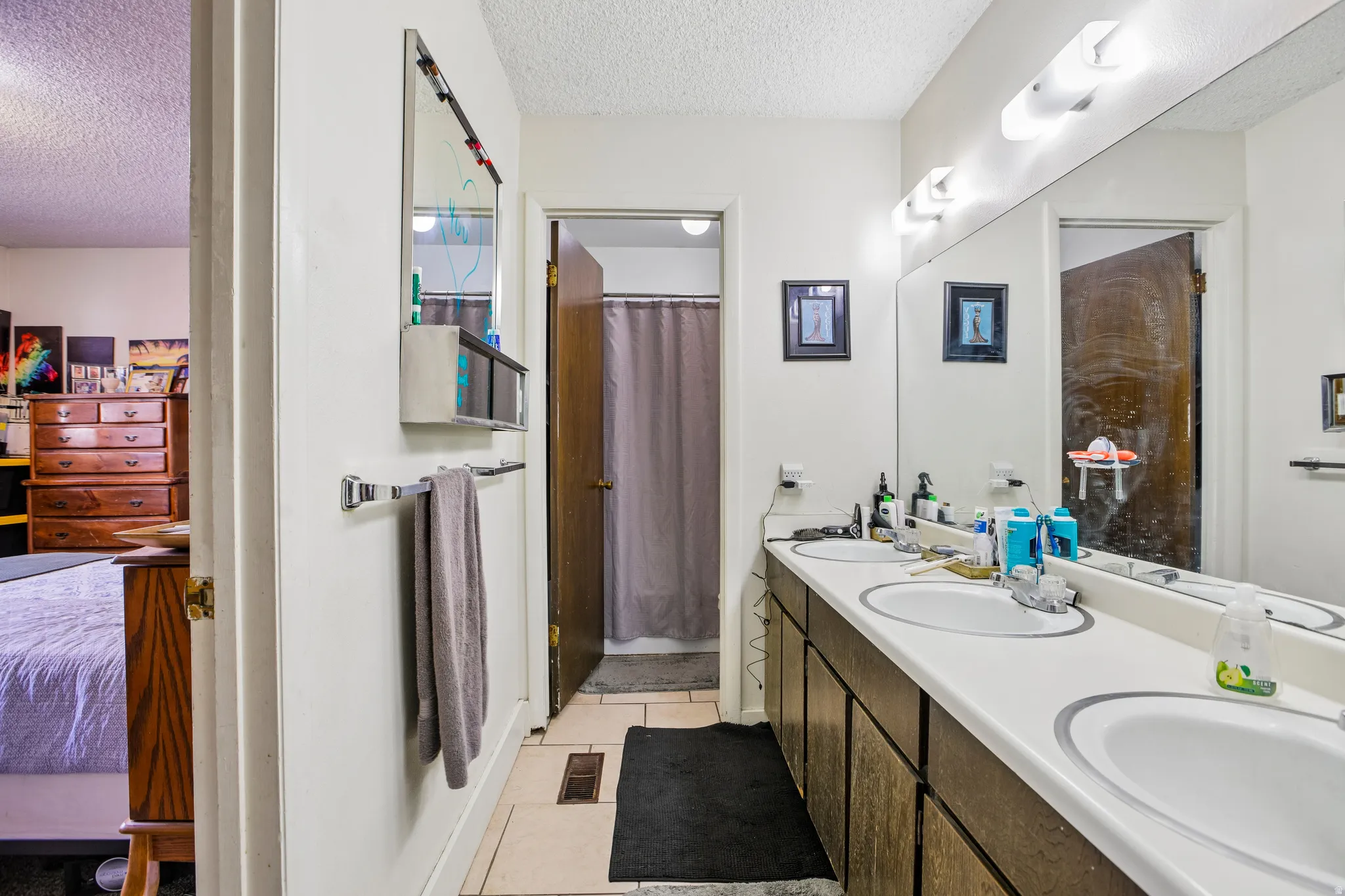Dual vanity with white countertops, integrated sinks, and overhead lighting