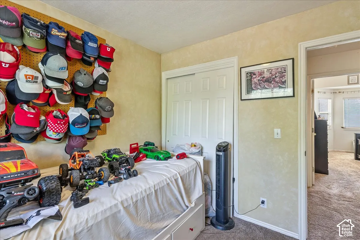 Room featuring textured wall finish, carpet flooring, a white sliding closet door, and a white interior door