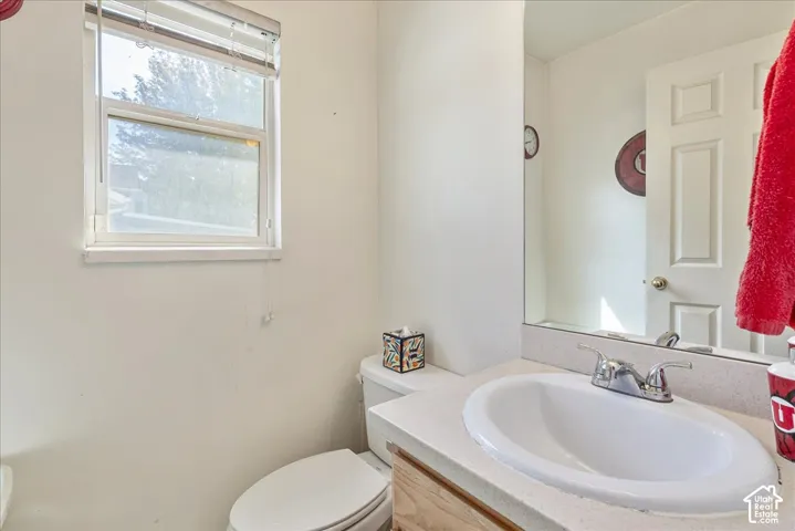 White vanity with integrated sink, chrome faucet, and expansive wall mirror