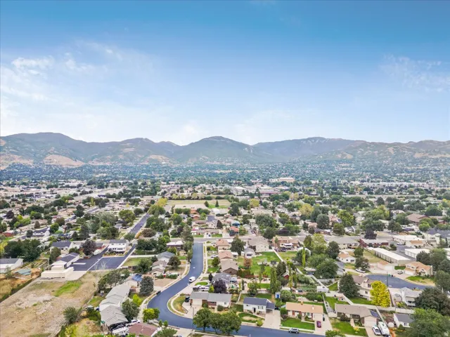 Expansive neighborhood setting with established homes, mature trees, and mountainous terrain
