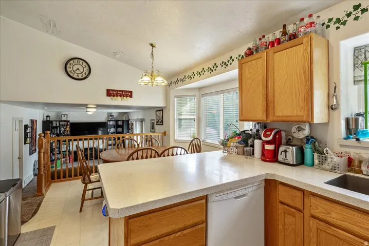 Kitchen featuring light wood cabinetry, light-toned countertops, and a stainless steel sink