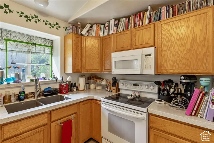 Recessed lighting, wood-finish cabinetry, built-in microwave, dual basin sink, and a multi-burner electric range