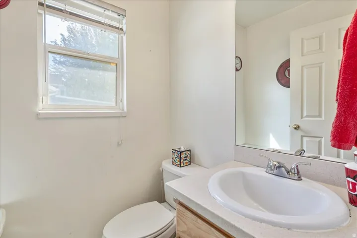 White vanity with integrated sink, chrome faucet, and expansive wall mirror