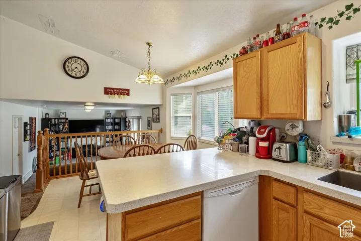 Kitchen featuring light wood cabinetry, light-toned countertops, and a stainless steel sink