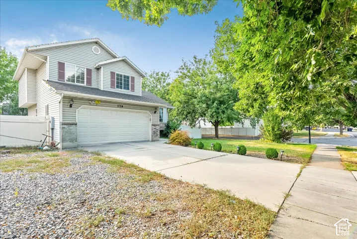 Two-story residence with light gray siding, an attached two-car garage, and a concrete driveway