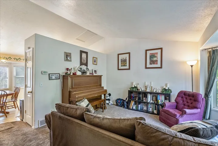 Vaulted ceiling, wall-to-wall carpeting, and a built-in bookshelf