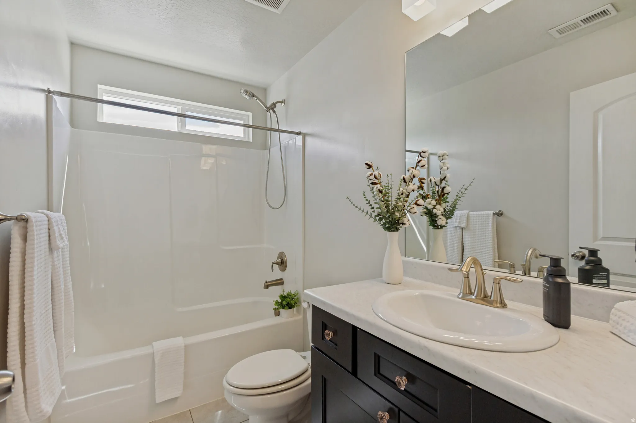 White tub and shower combination with a transom window.