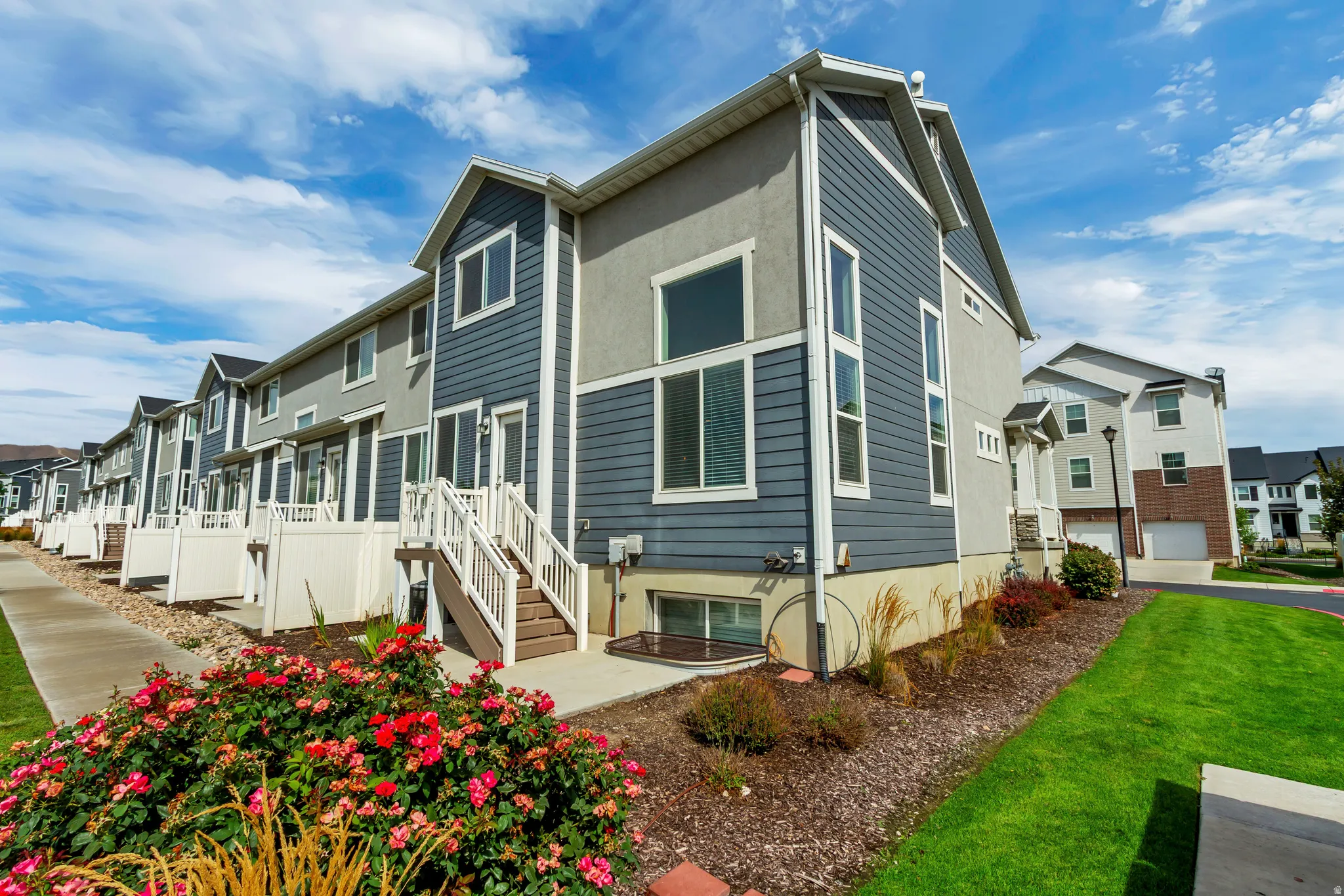 Contemporary townhouse with multi-tone siding, prominent windows, and a private rear deck.