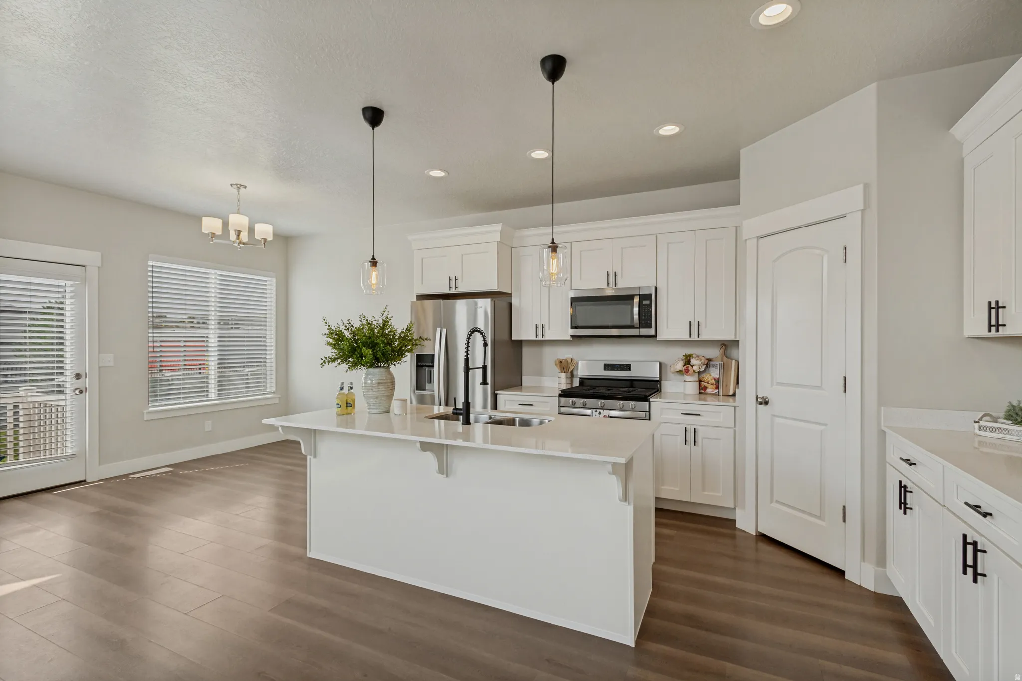 White cabinetry, stainless steel appliances, central island with new dishwasher, wood-finish flooring, and recessed lighting.