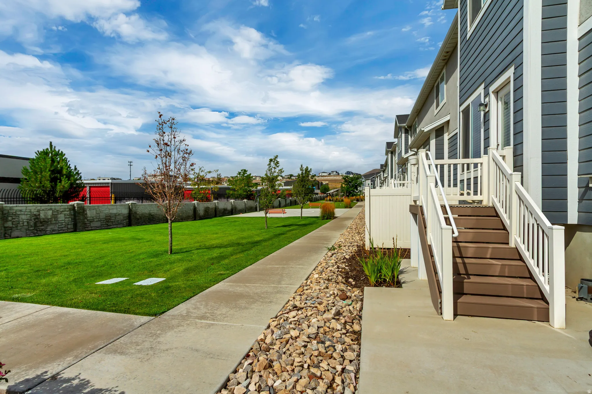 Multi-level townhouse exterior with dark blue siding and white trim.
