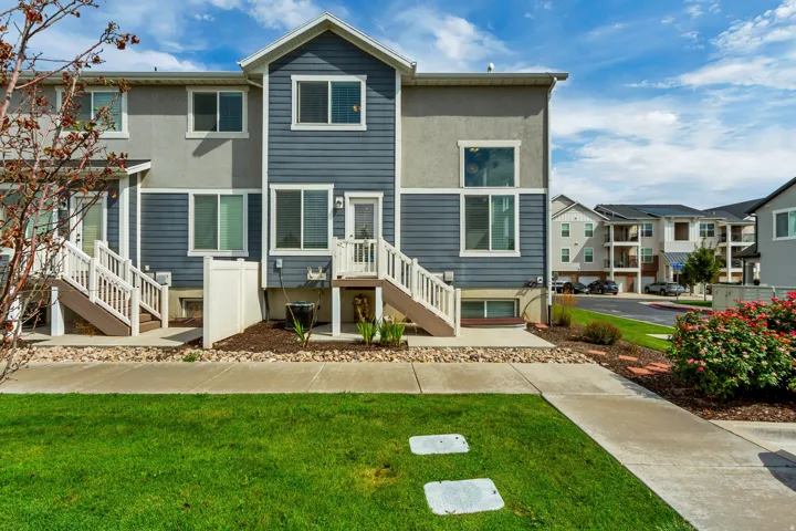 Multi-level townhouse exterior featuring blue siding and light grey stucco.