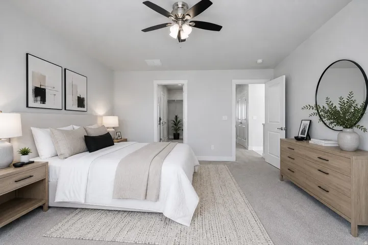 Owners bedroom with wonderful natural light, neutral wall paint, ceiling fan with brushed nickel accents, neutral new carpet flooring, recessed lighting, and white interior doors.