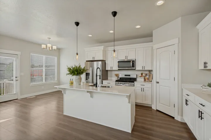 White cabinetry, stainless steel appliances, central island with new dishwasher, wood-finish flooring, and recessed lighting.