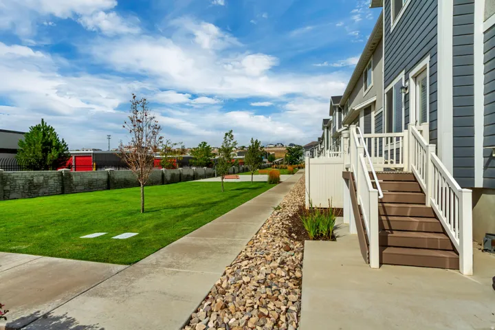Multi-level townhouse exterior with dark blue siding and white trim.