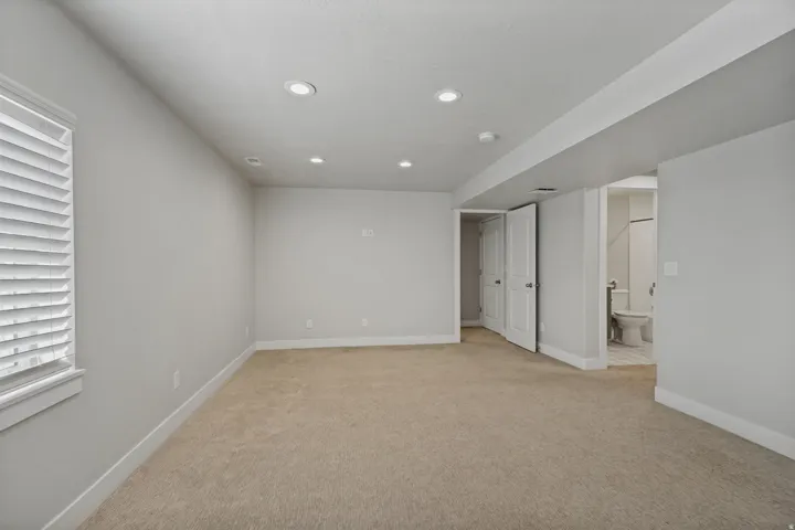 Recessed lighting, neutral-toned walls, and carpeted flooring.
