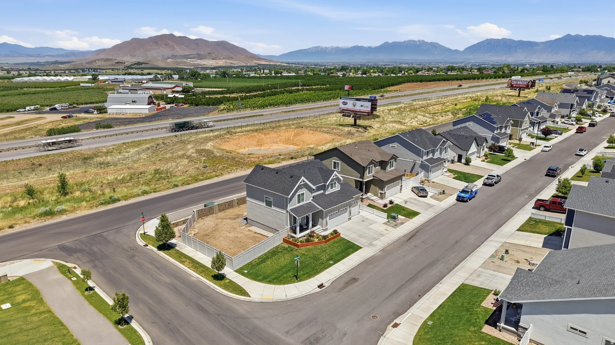 Residential street with sidewalk access, featuring a uniform row of homes and mountain scenery in the distance