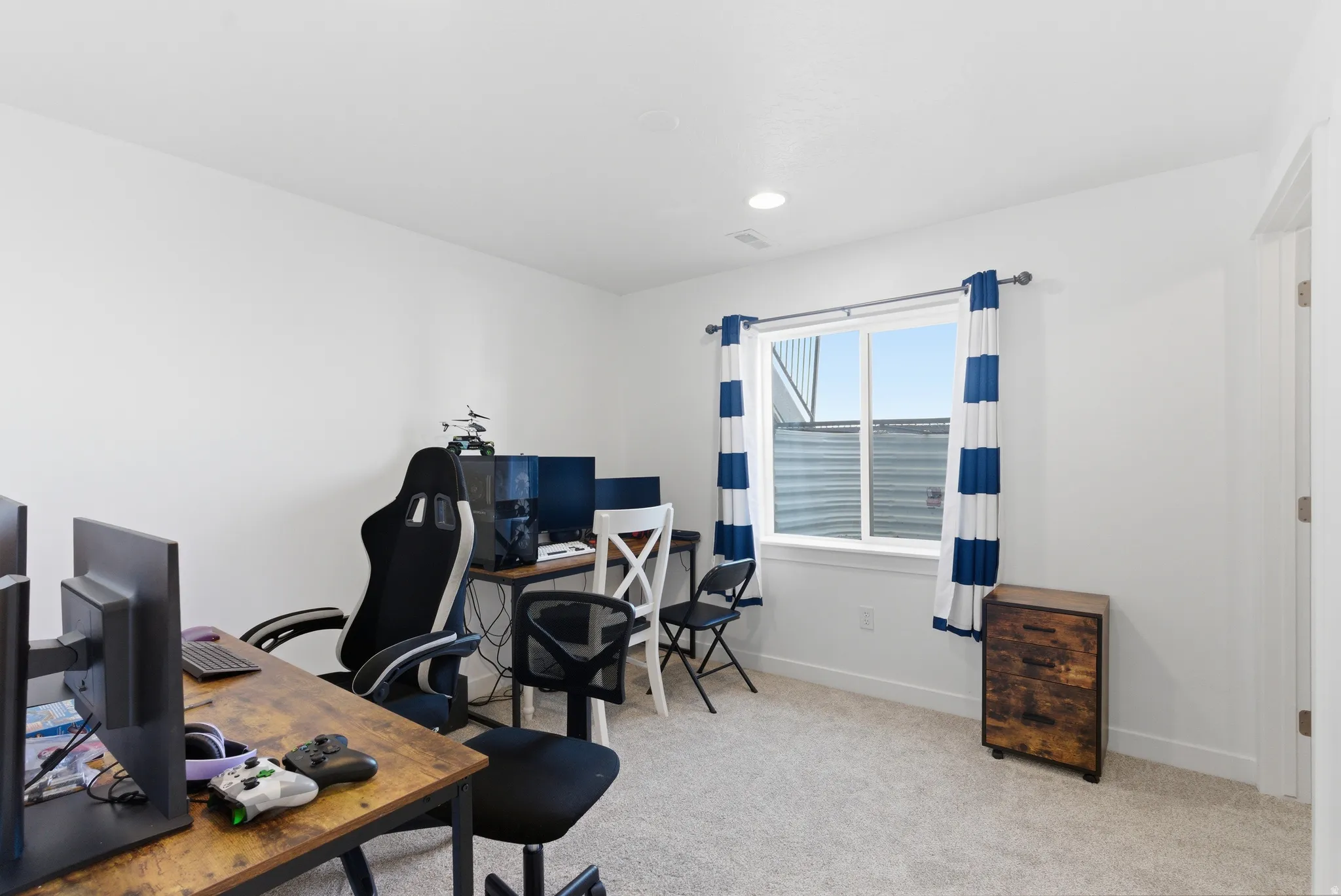 Recessed lighting, light-toned carpeting, white walls, and a window with white trim