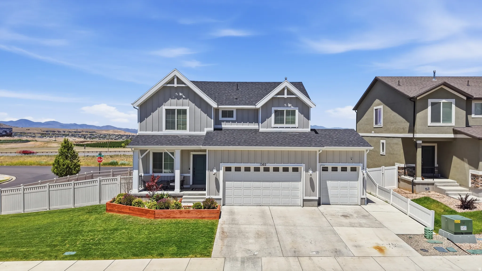 Siding exterior with a covered porch, two-car garage, and fenced perimeter