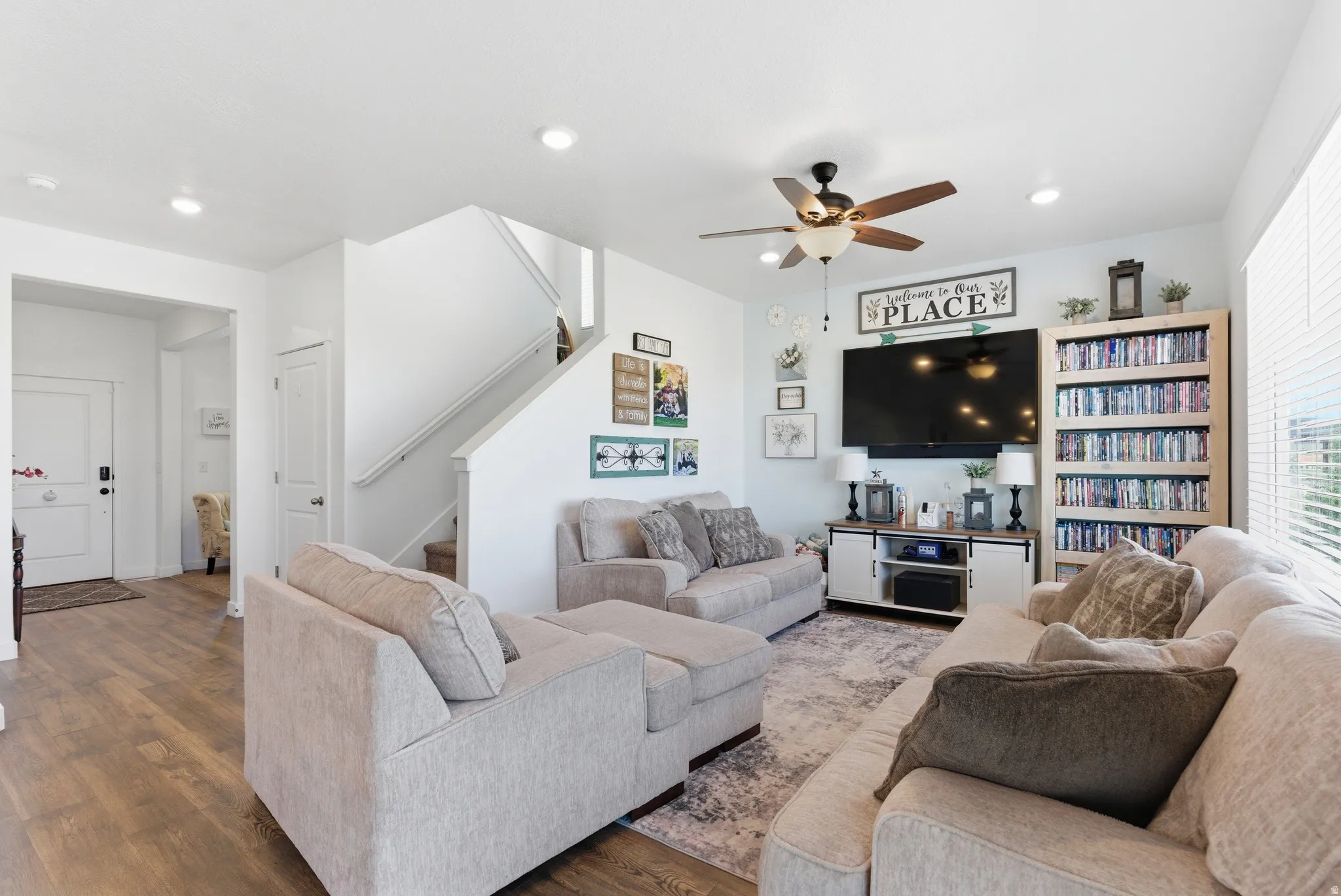 Recessed lighting, wood-finish flooring, ceiling fan with light fixture, and staircase with painted railing