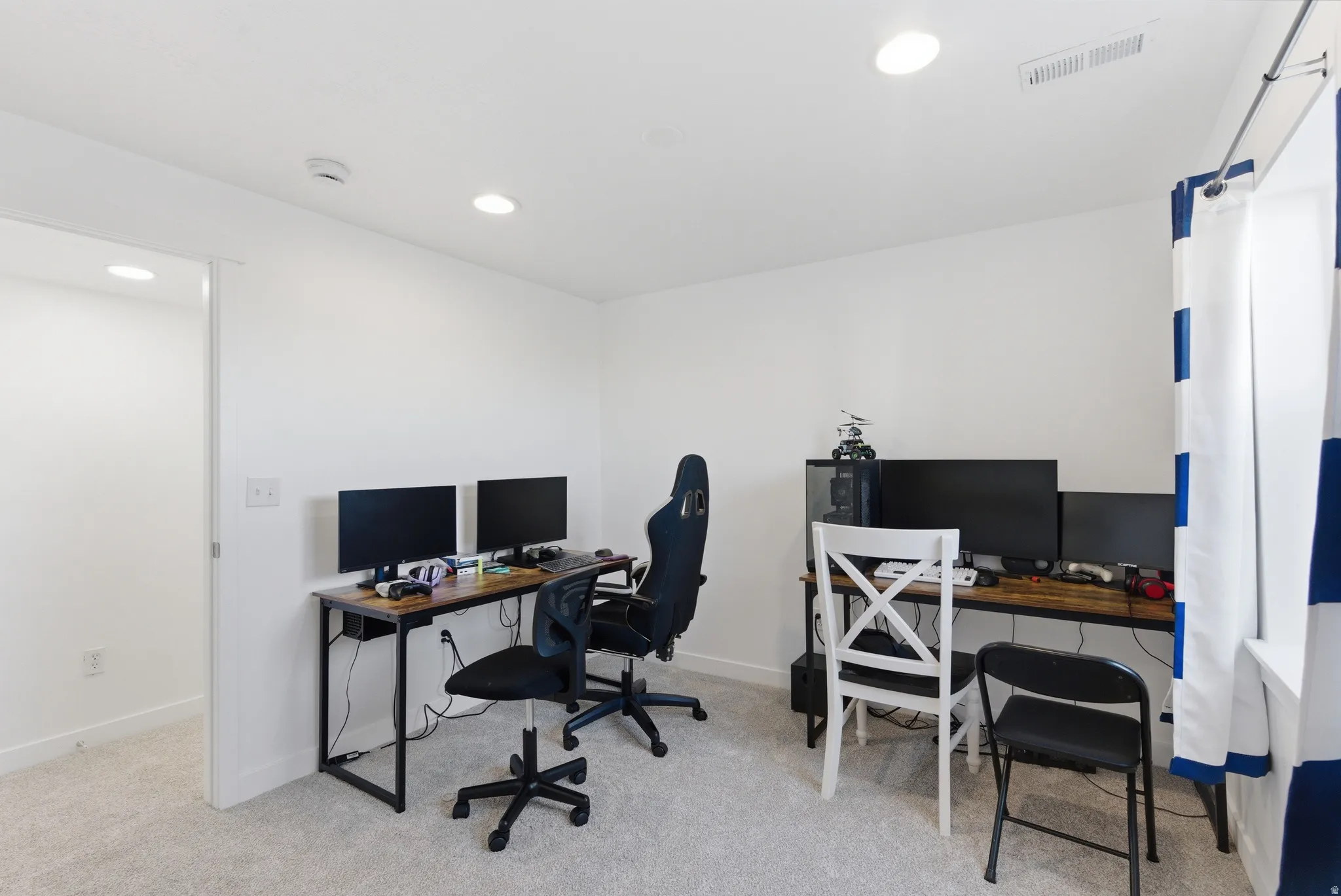 Neutral wall paint, recessed lighting, light-toned carpeting, white trim, and a window opening