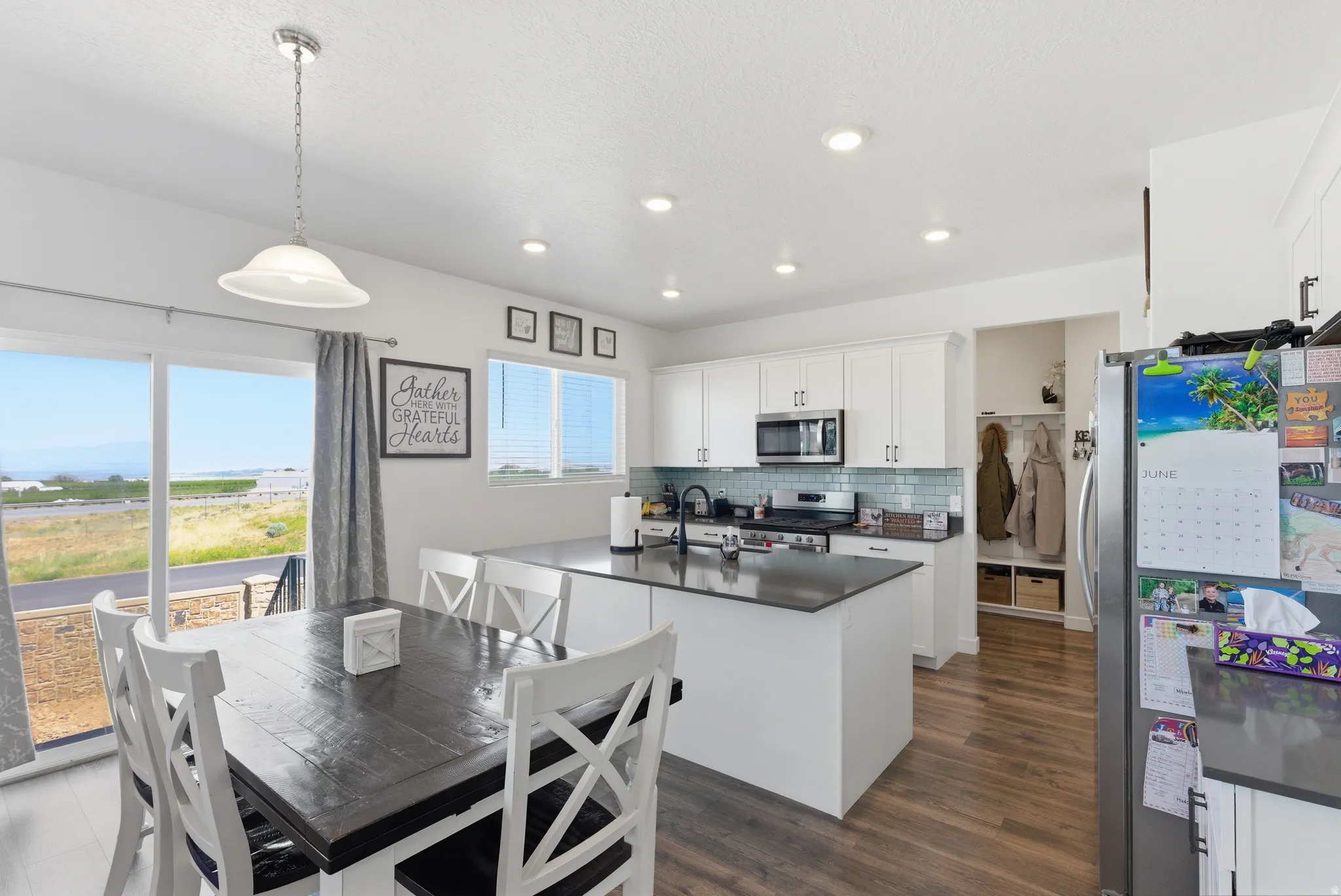 Open-concept kitchen with white cabinetry and dark countertops