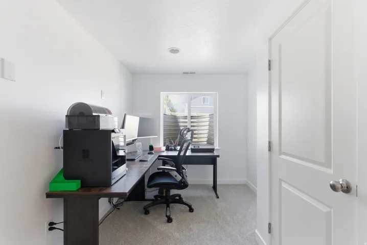 Carpeted room featuring a white paneled door, recessed lighting, and a window