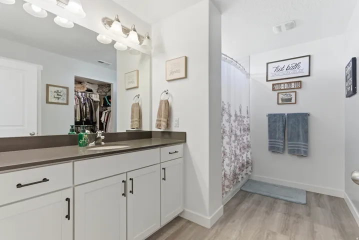 White vanity cabinetry with dark hardware and a contrasting countertop