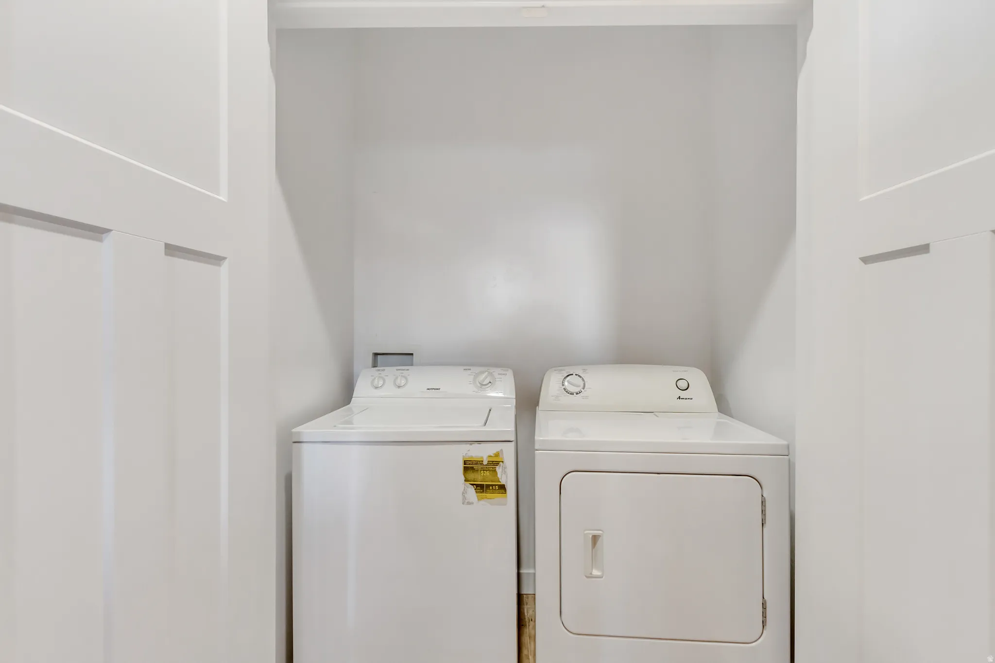 Built-in laundry closet featuring a white top-load washer and white dryer