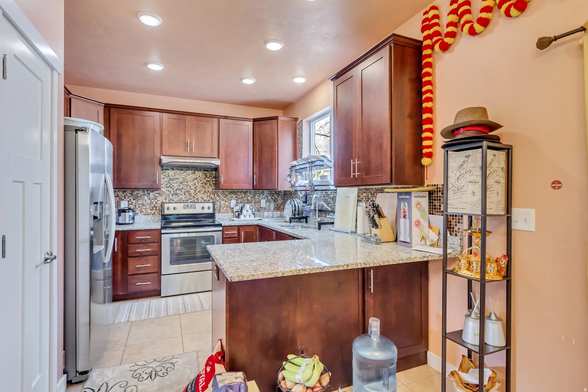 Kitchen featuring wood-finish cabinetry, light-toned countertops, and a full suite of stainless steel appliances