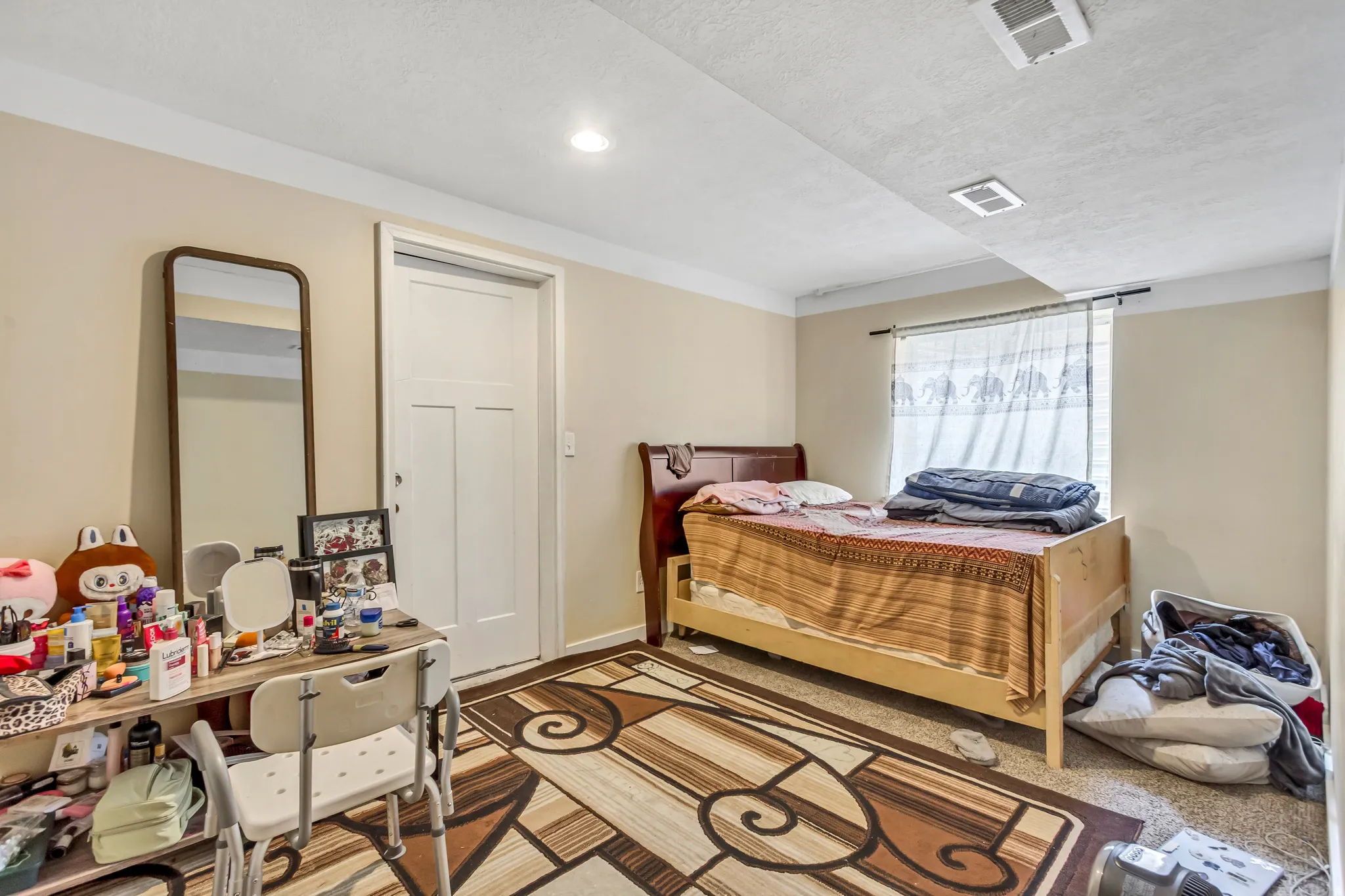 Recessed lighting, window with curtain rod, and a solid interior door