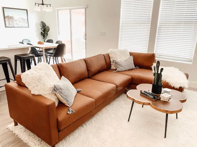 Open-concept living space featuring light wood-finish flooring, a contemporary chandelier, and a sliding glass door