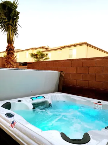 Outdoor spa with integrated lighting, a water feature, and built-in seating